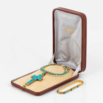 An 18K gold and turquoise cross with a chain and a 14K gold bracelet set with turquoises.