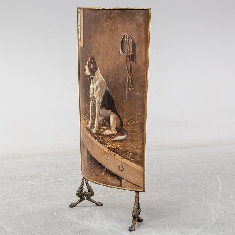 A 19th century brass fire shield decorated with paint of hunting dog setter in the stable.