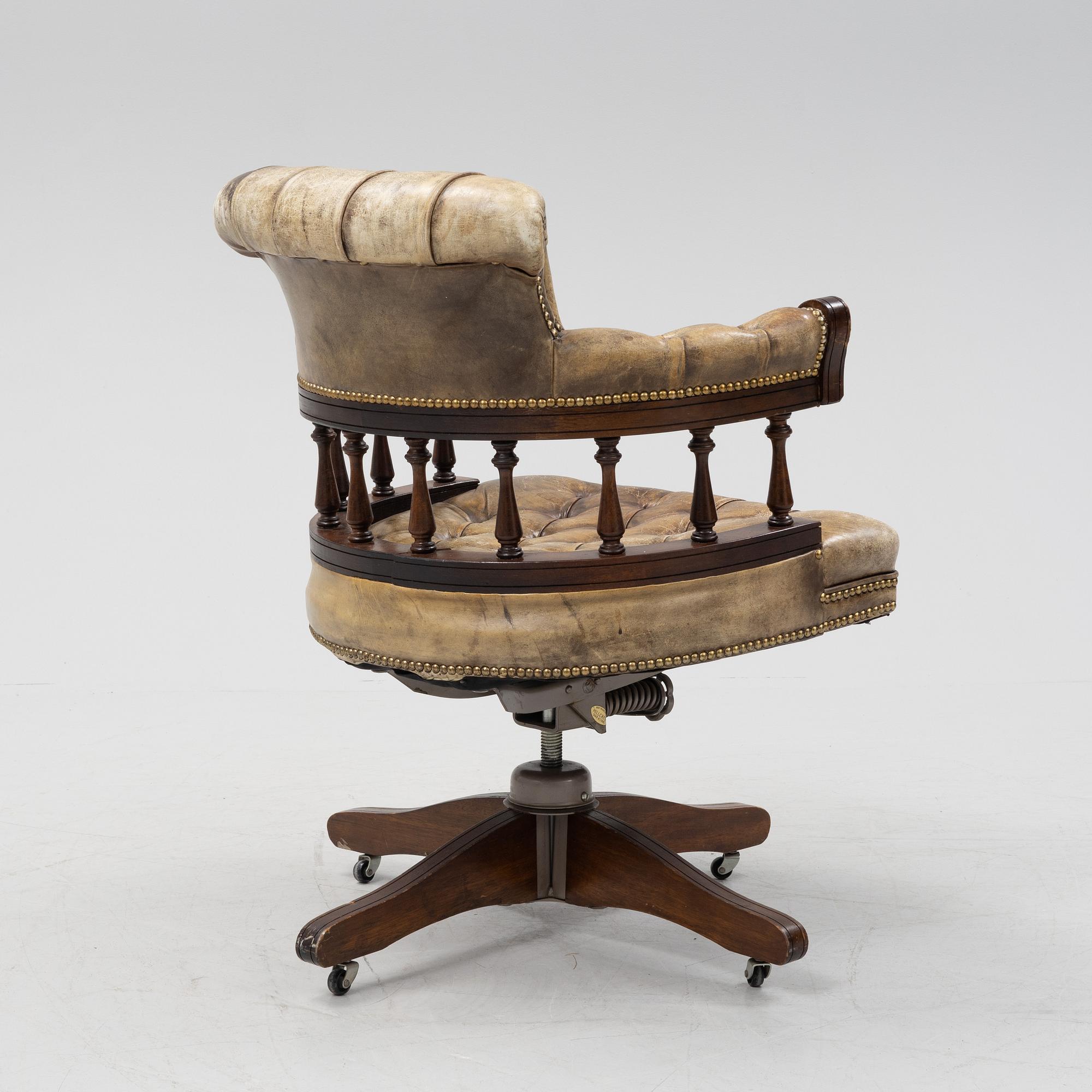A 20th Century English mahogany and leather desk chair by Hillcrest Chair Actions.