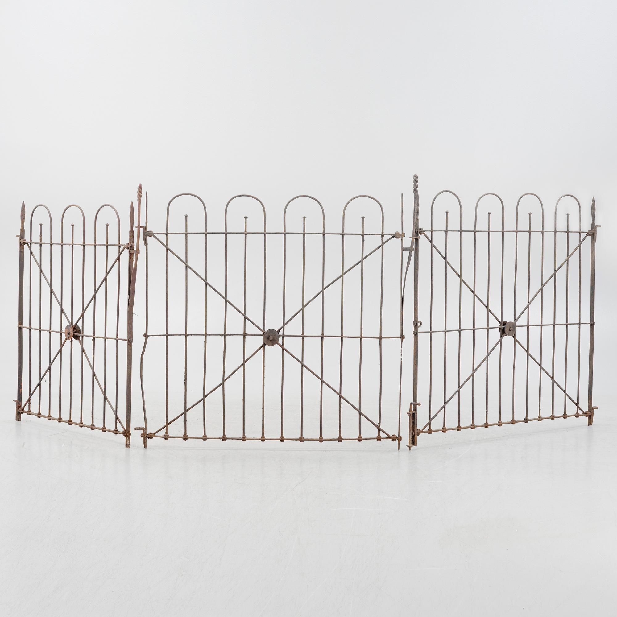 A pair of iron garden gates and a single gate from the early 20th century.