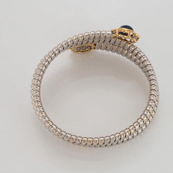 An 18K gold bangle set with cabochon-cut sapphires and round brilliant-cut diamonds.