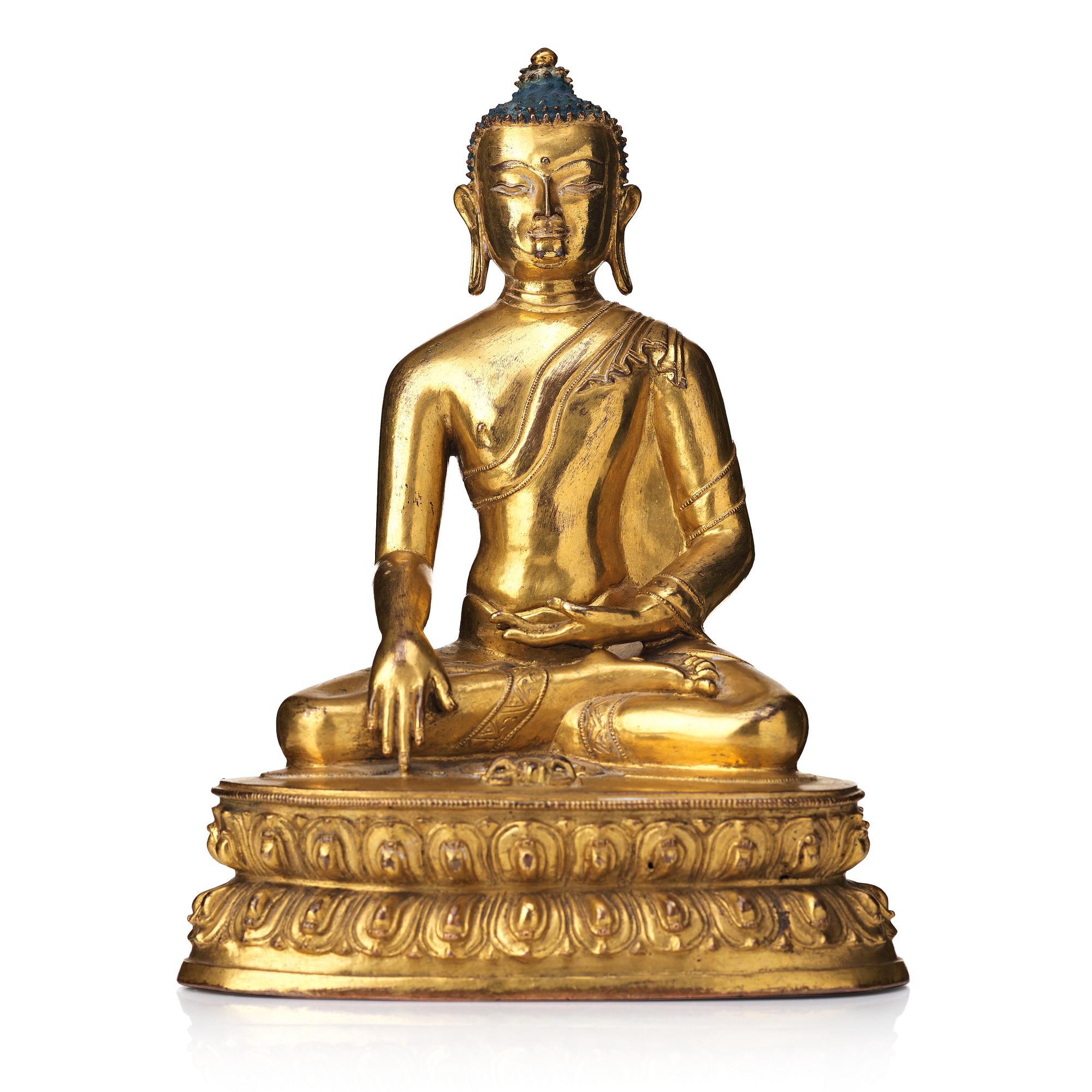 A gilt copper alloy figure of Akhsobya buddha, Tibet, 15th Century.