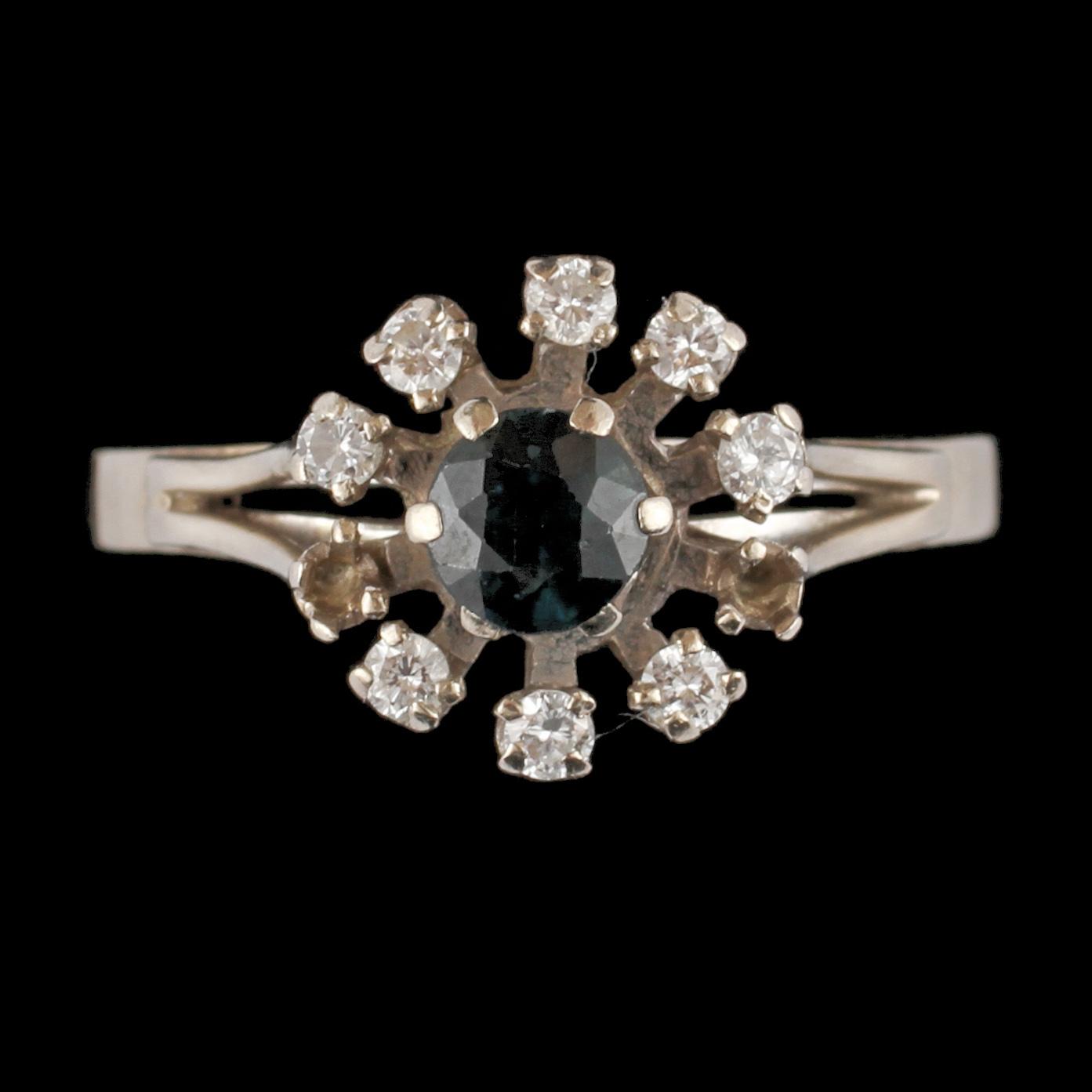 RING, 18k vitguld med fasettslipad blå safir samt 8 briljantslipade diamanter, 1900-talets tredje kvartal. Vikt 4 g.