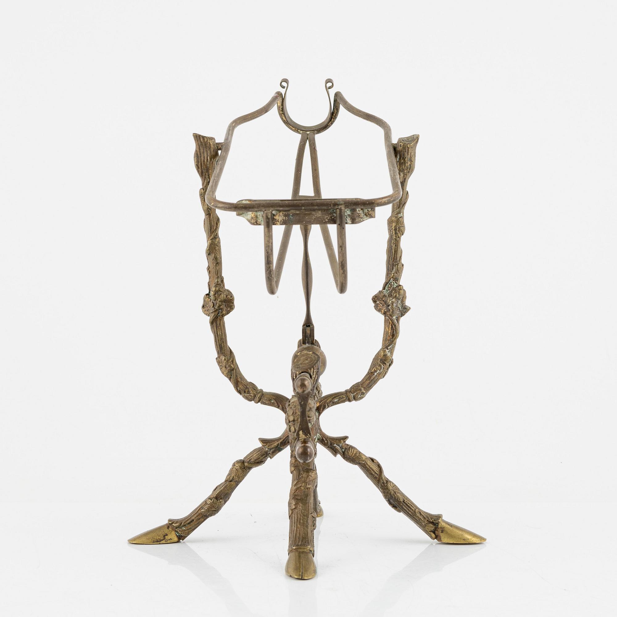 A brass bottle holder, circa 1900.