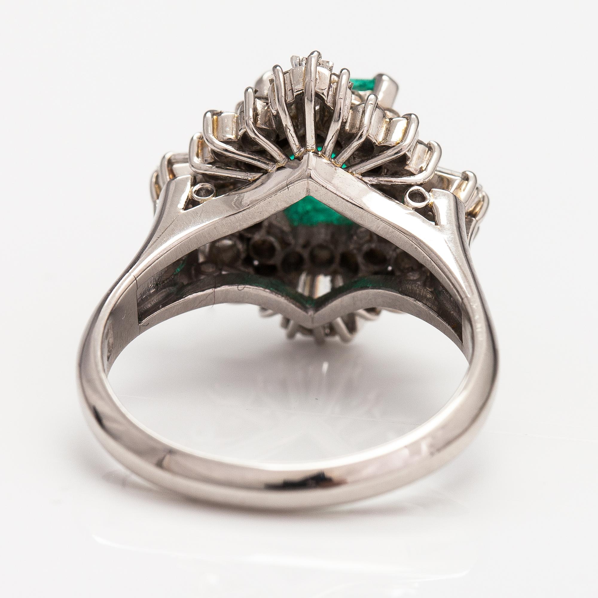 A platinum ring with a ca. 1.15 ct emerald and ca. 1.00 cts of diamonds in total.