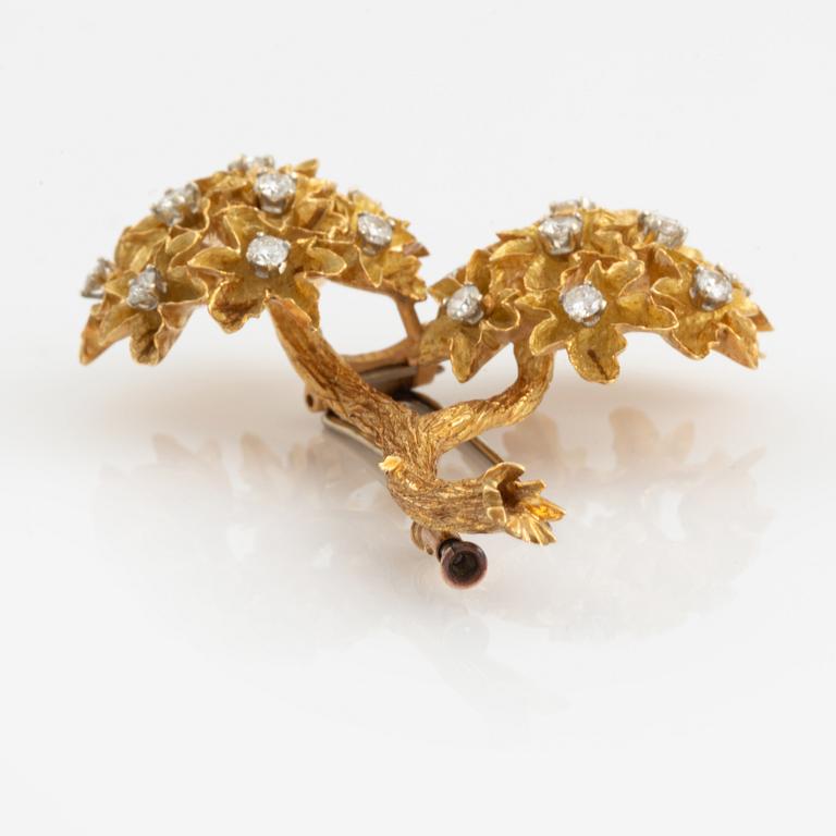 An 18K gold brooch set with round brilliant-cut diamonds.