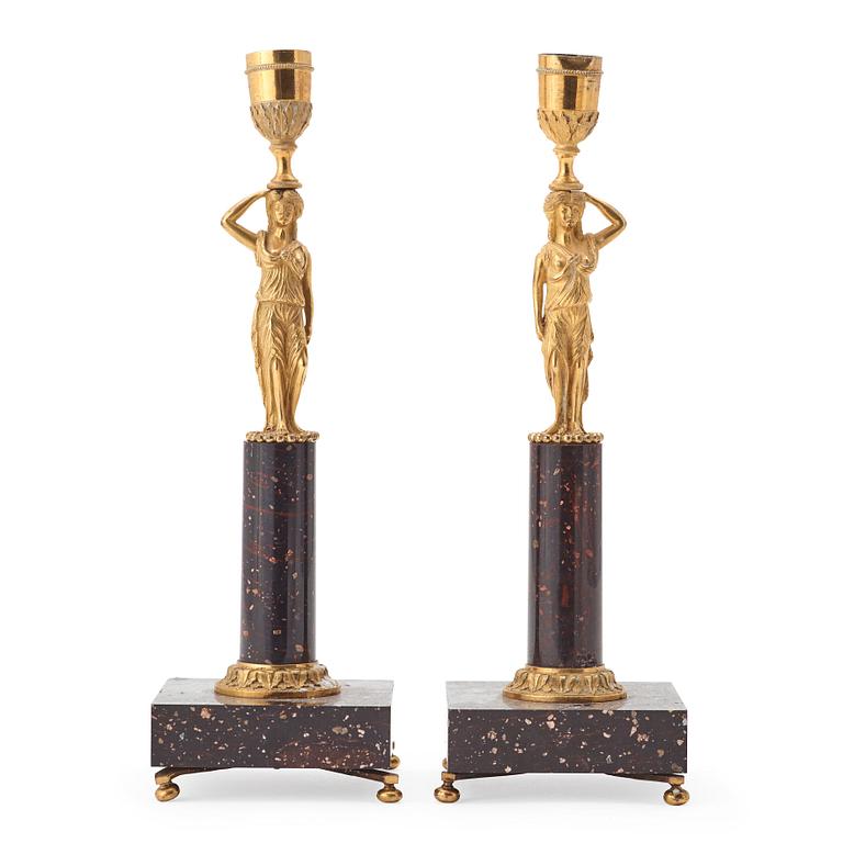 A pair of late gustavian early 19th century porphyry and ormolu candlesticks.