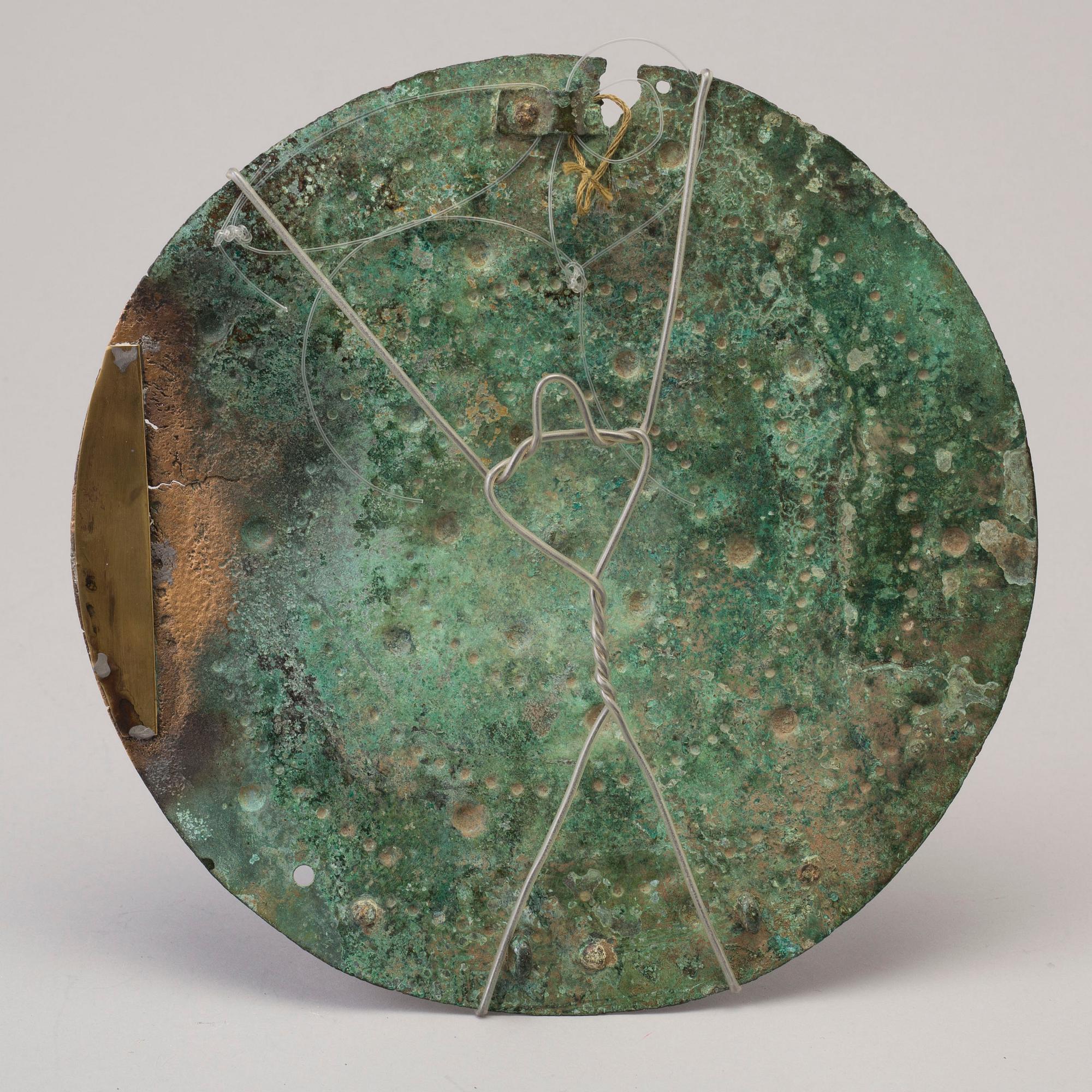 Three 20th century stone objects, with one bronze shield.
