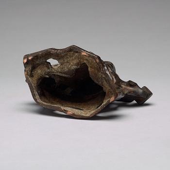 A bronze sculpture of a seated scholar with books, Qing dynasty (1644-1912).