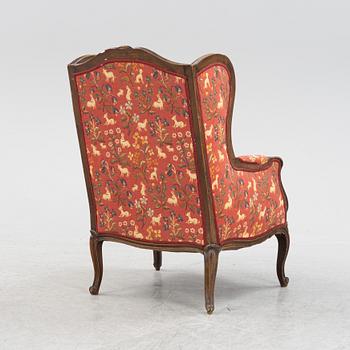 A Louis XV style easy chair from around the year 1900.