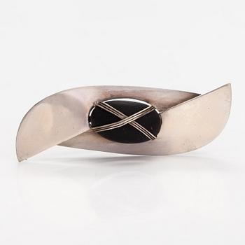 Paula Häiväoja, A sterling silver and natural stone brooch "Kiveen sidottu musta". Pentti Roos/Studio Paula, Helsinki.