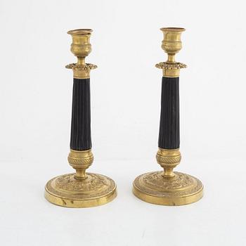 A pair of brass candle sticks, late empire, mid 19th century.