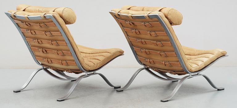 A pair of Arne Norell "Ari" brown leather and steel easy chairs by Norell.