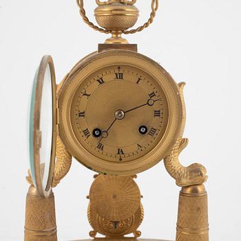 An Empire-style gilt bronze mantel clock and a pair of candlesticks, 20th century.