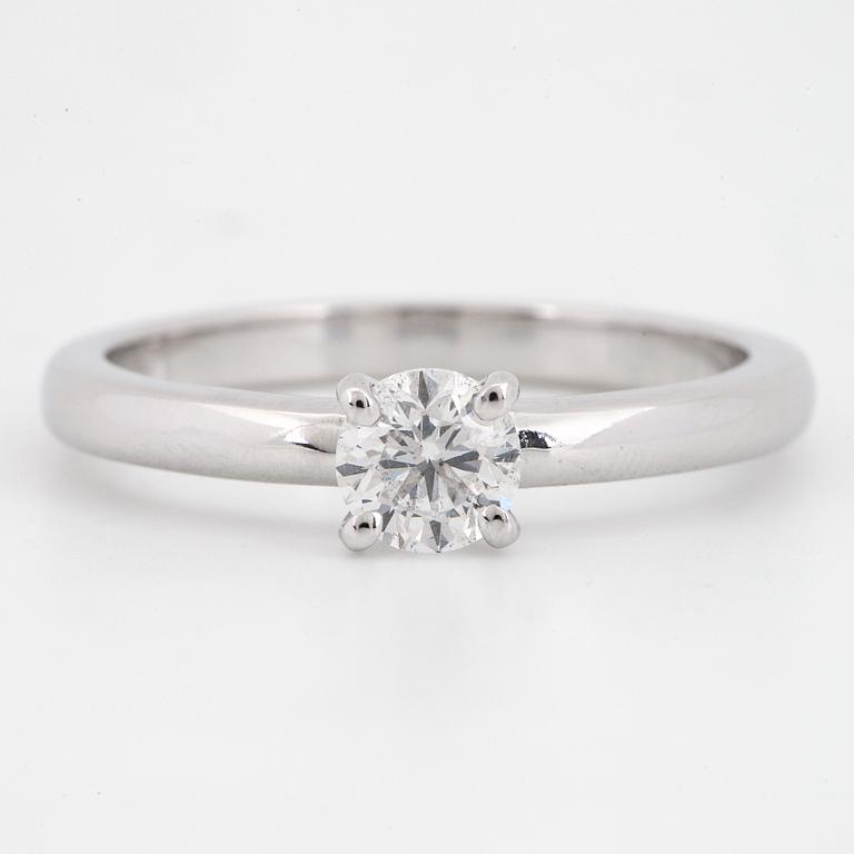An 18K white gold ring set with a round brilliant-cut diamond.