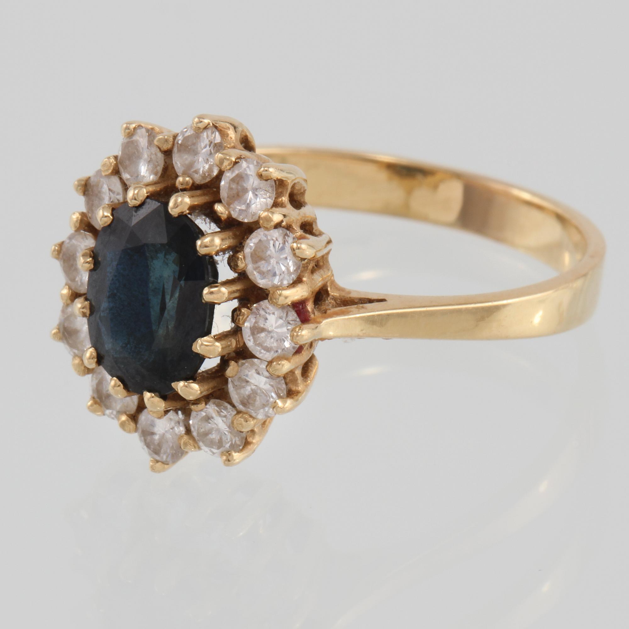 RING, 18K guld med ovalslipad blå safir samt 12 briljantslipade diamanter 0.73 ct, kattfotstämplad. Vikt 5,3 gram.
