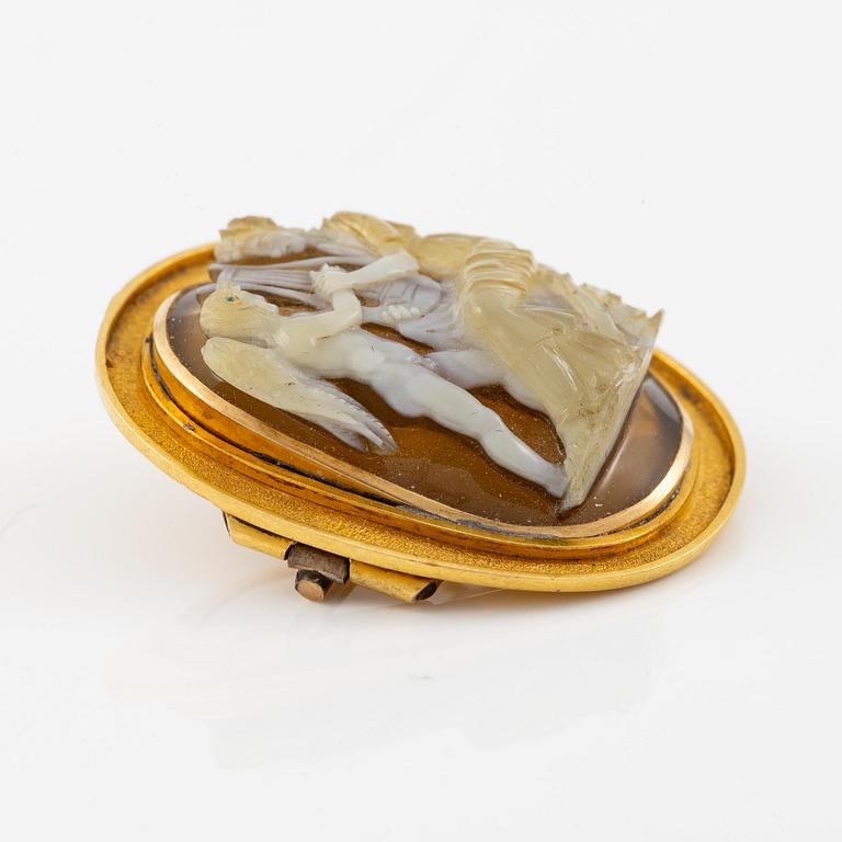 A brooch in 18K gold with a hardstone cameo.