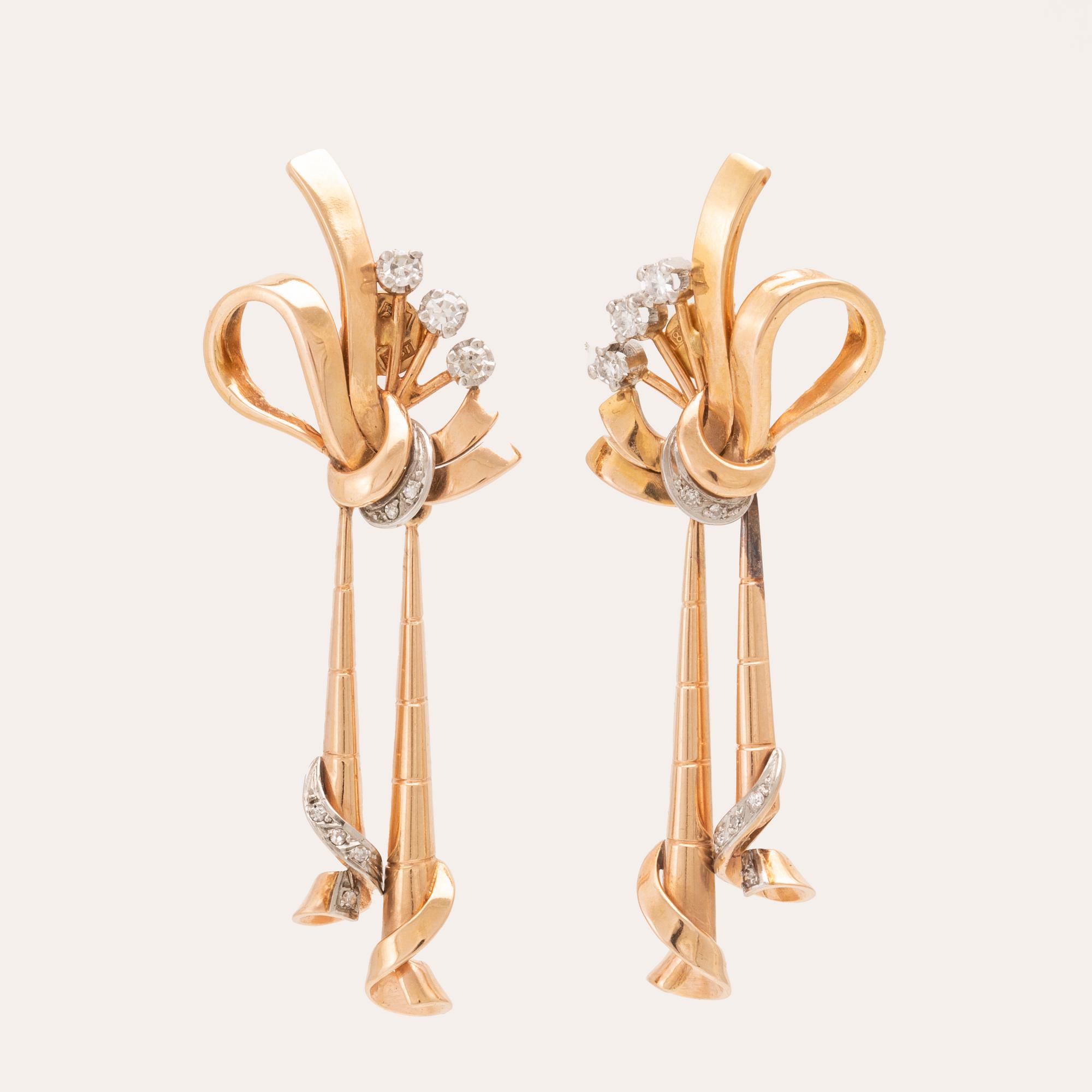 A pair of 18K white and red gold earrings set with single cut diamonds.