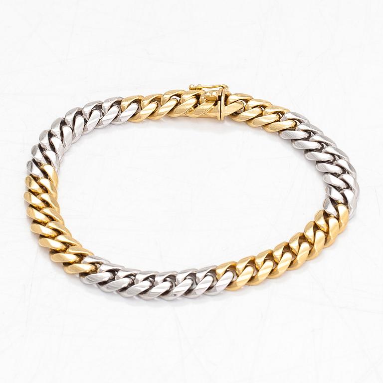 An 18K white/yellow gold curb link bracelet. Foreign marks.
