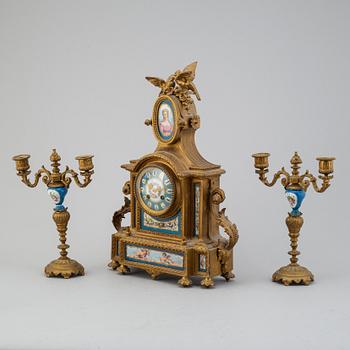 A table clock and two candelabras from the late 19th century.