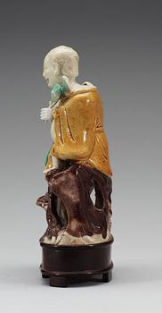 A green, yellow and brown glazed biscuit figure of Laughing boys, Qing dynasty, Kangxi (1662-1722).