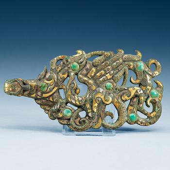 1832. An archaistic silver gilt bronze garment hook inlayed with green stone,