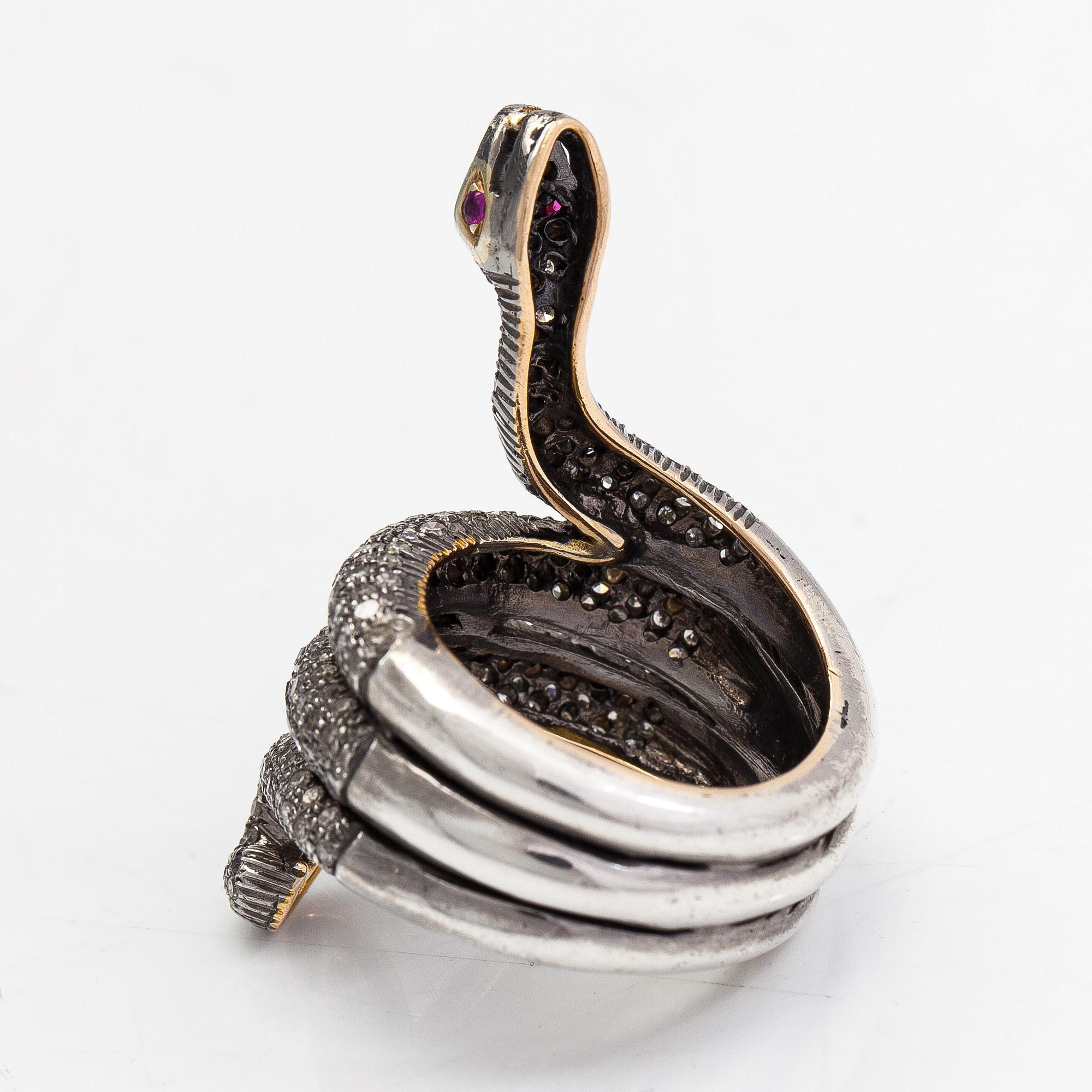 A serpent ring in gold and silver with rubies and single cut diamonds ca 0.88 ct in total.