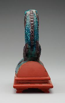 A turquoise and purple glazed roof top tile in the shape of a fish, Ming dynasty.