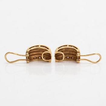 A pair of 18K gold earrings set with small diamonds.