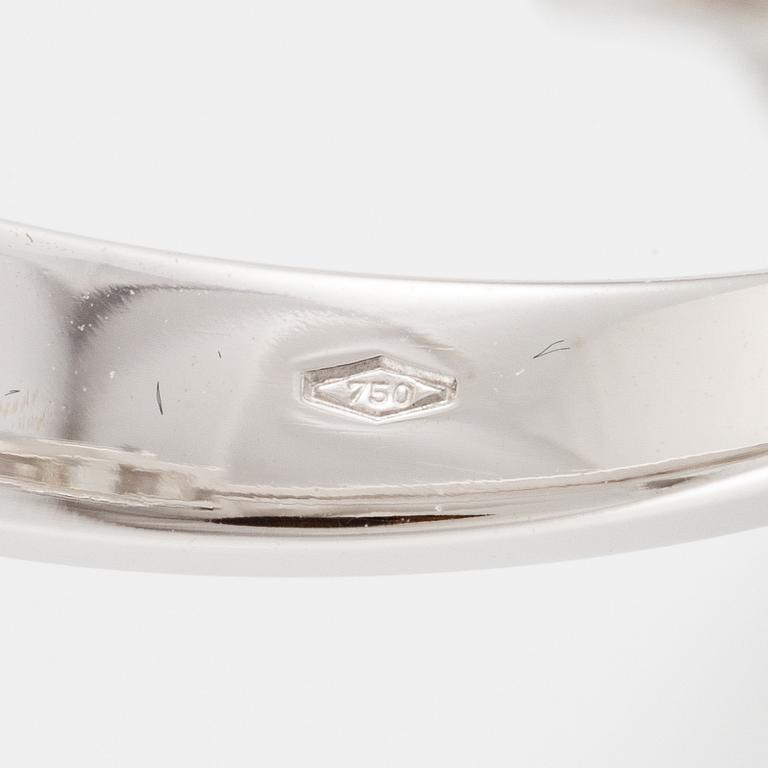 An 18K white gold ring set with three emerald-cut diamonds.