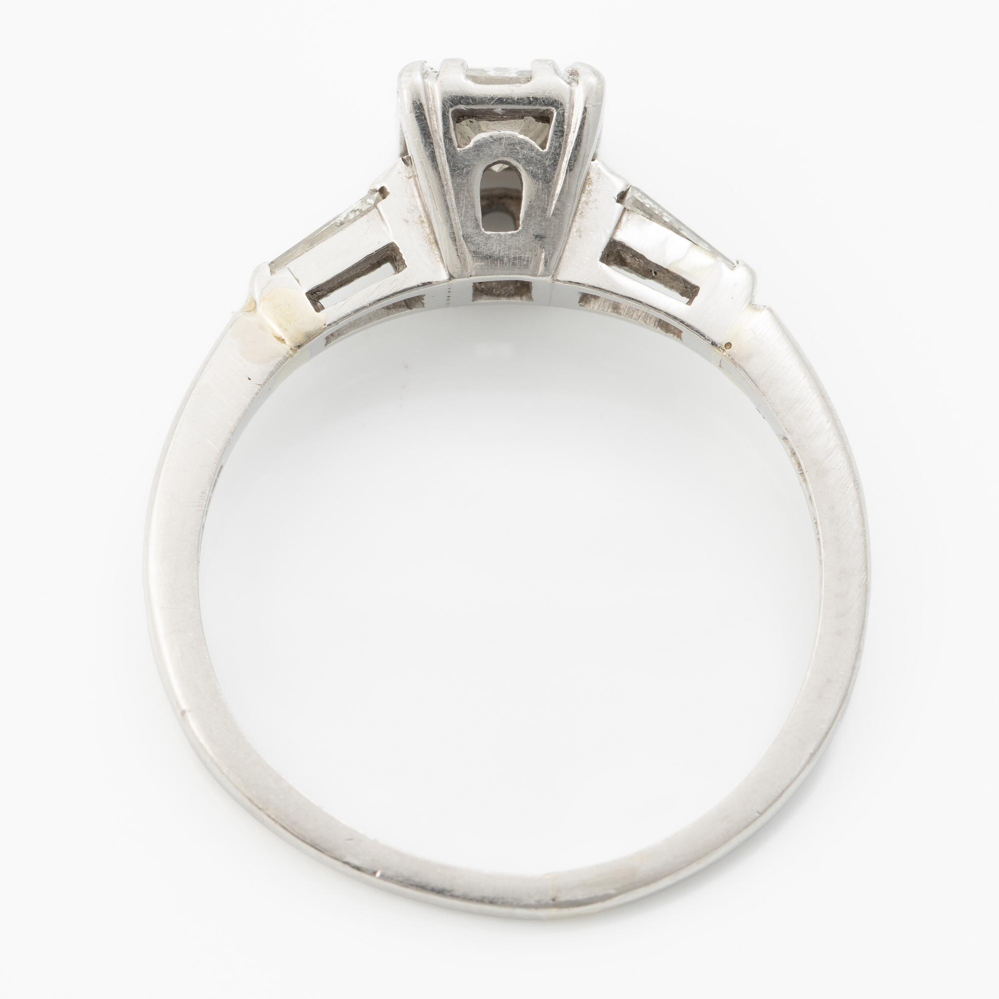 Platinum ring with an emerald-cut diamond and modified baguette-cut diamonds.