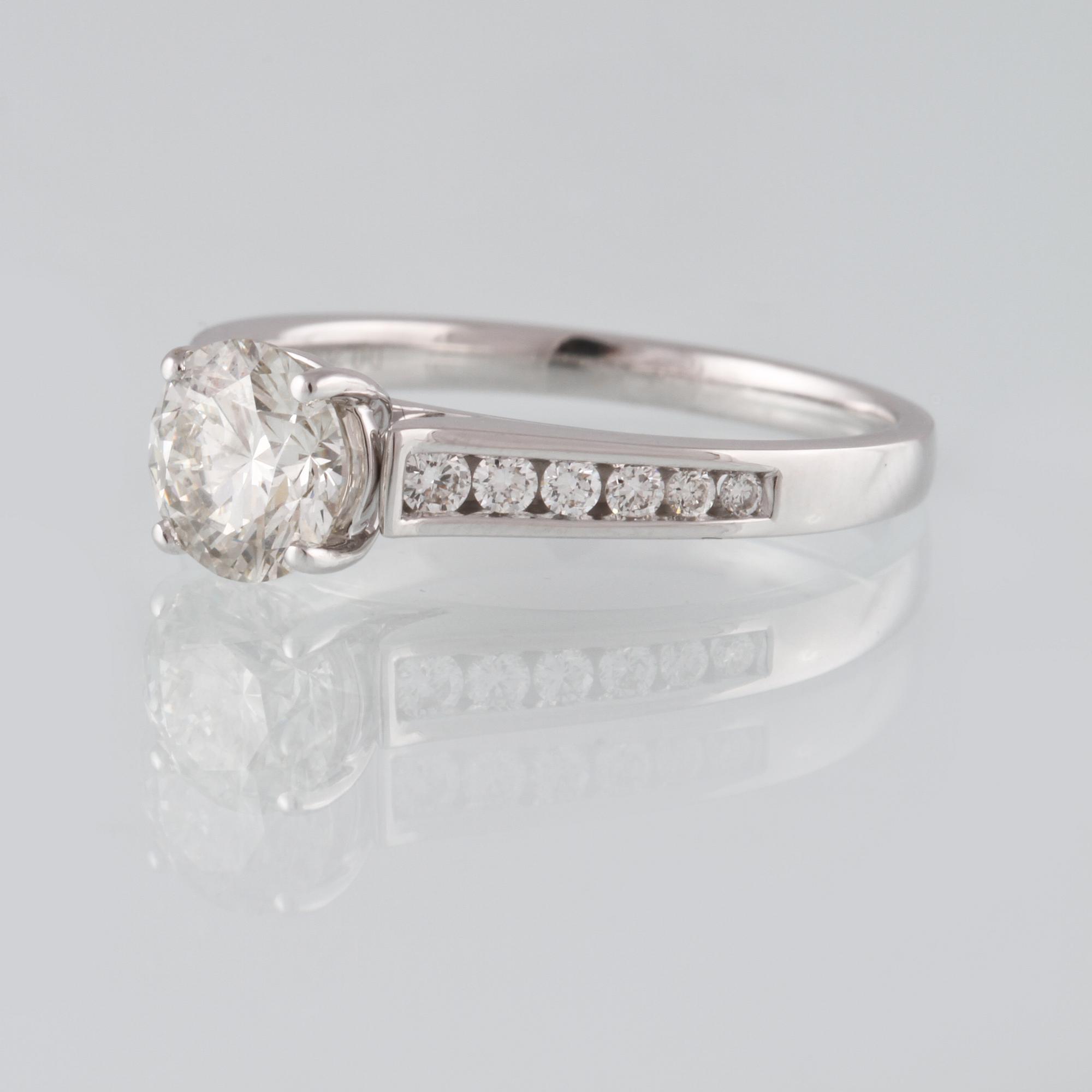 RING, 18K vitguld med briljantslipad diamant 1.01 ct samt 12 briljantslipade diamanter 0.20 ct. Vikt 3,6 gram.
