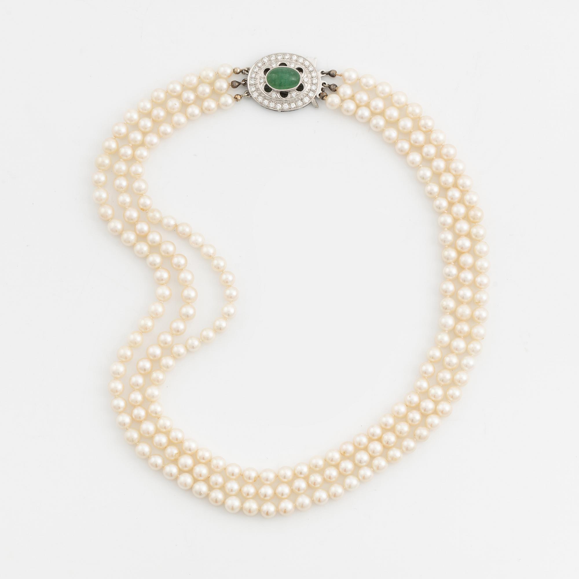 Three-row pearl necklace with cultured pearls, clasp with cabochon-cut emerald and brilliant-cut diamonds.
