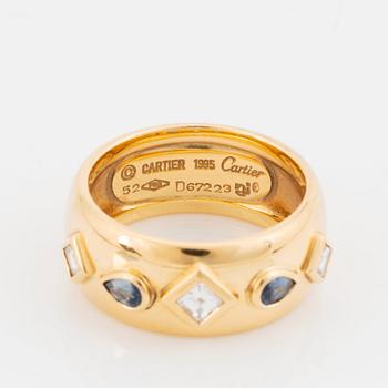 An 18K gold Cartier ring set with step-cut diamonds and faceted sapphires.