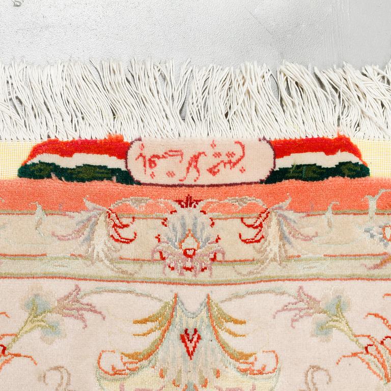 A Täbriz rug, signed, part silk, 210 x 148 cm.