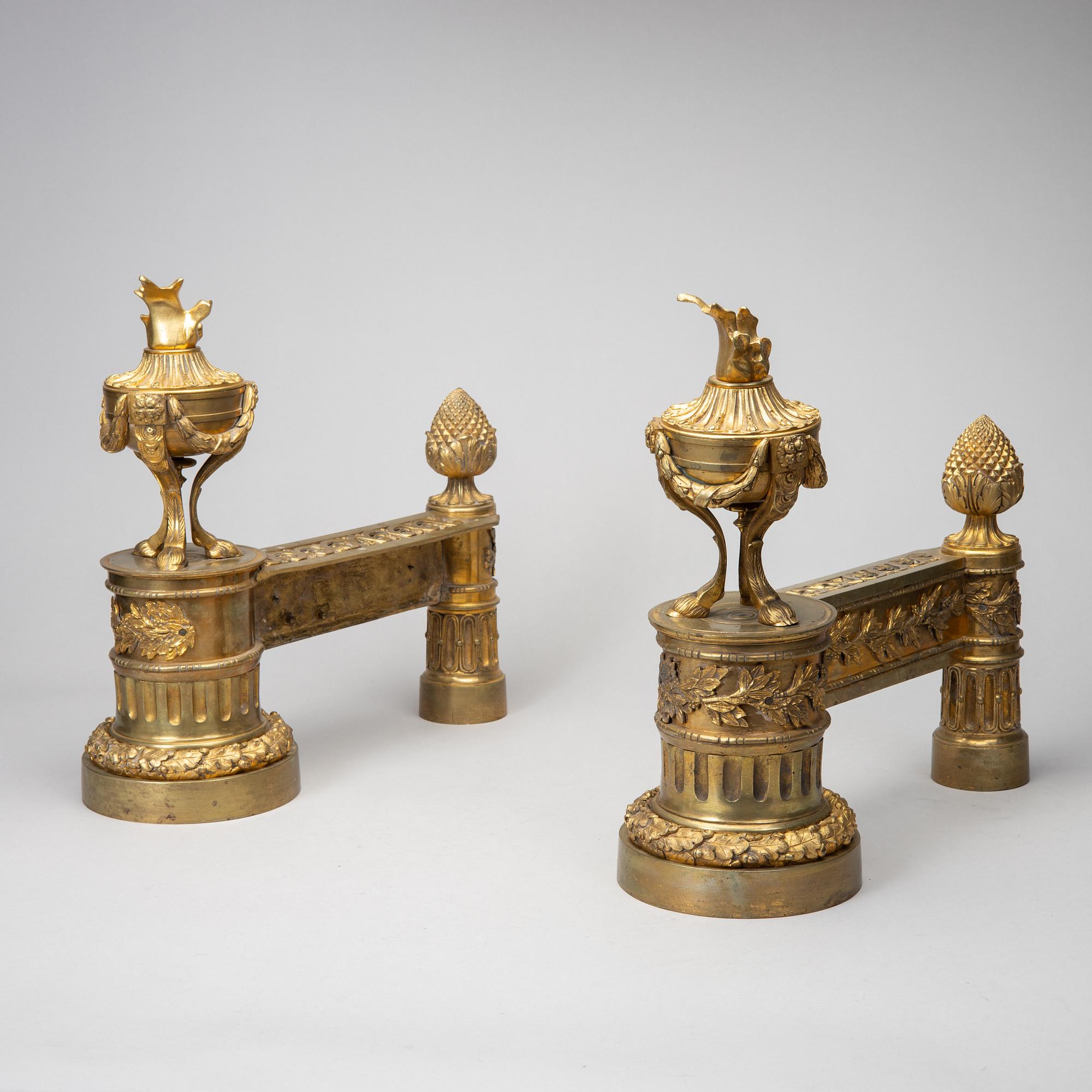 A pair of gilt brass Louis-XVI style andirons, second half of the 19th Century.