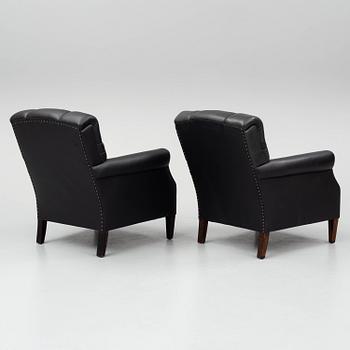 A pair of leather armchairs, early 20th century.