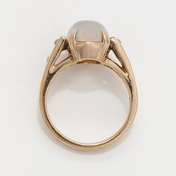 Ring in 14K gold with an oval opal and diamonds.