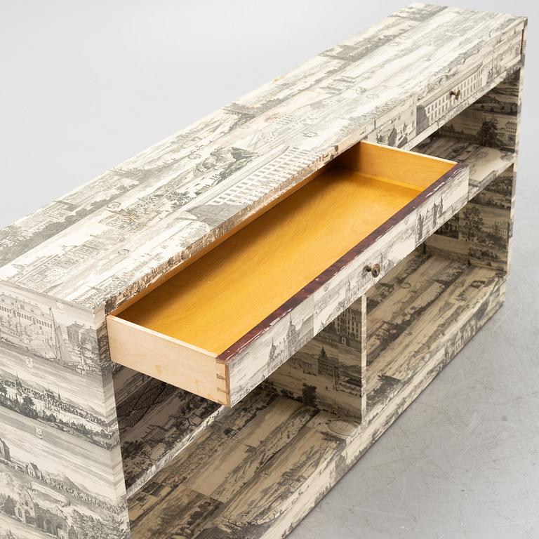 A bookcase decorated in prints from Dahlbergs Suecia antiqua et hodierna, mid 20th century.