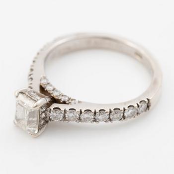 18K white gold ring set with an emerald-cut diamond and round brilliant-cut diamonds.