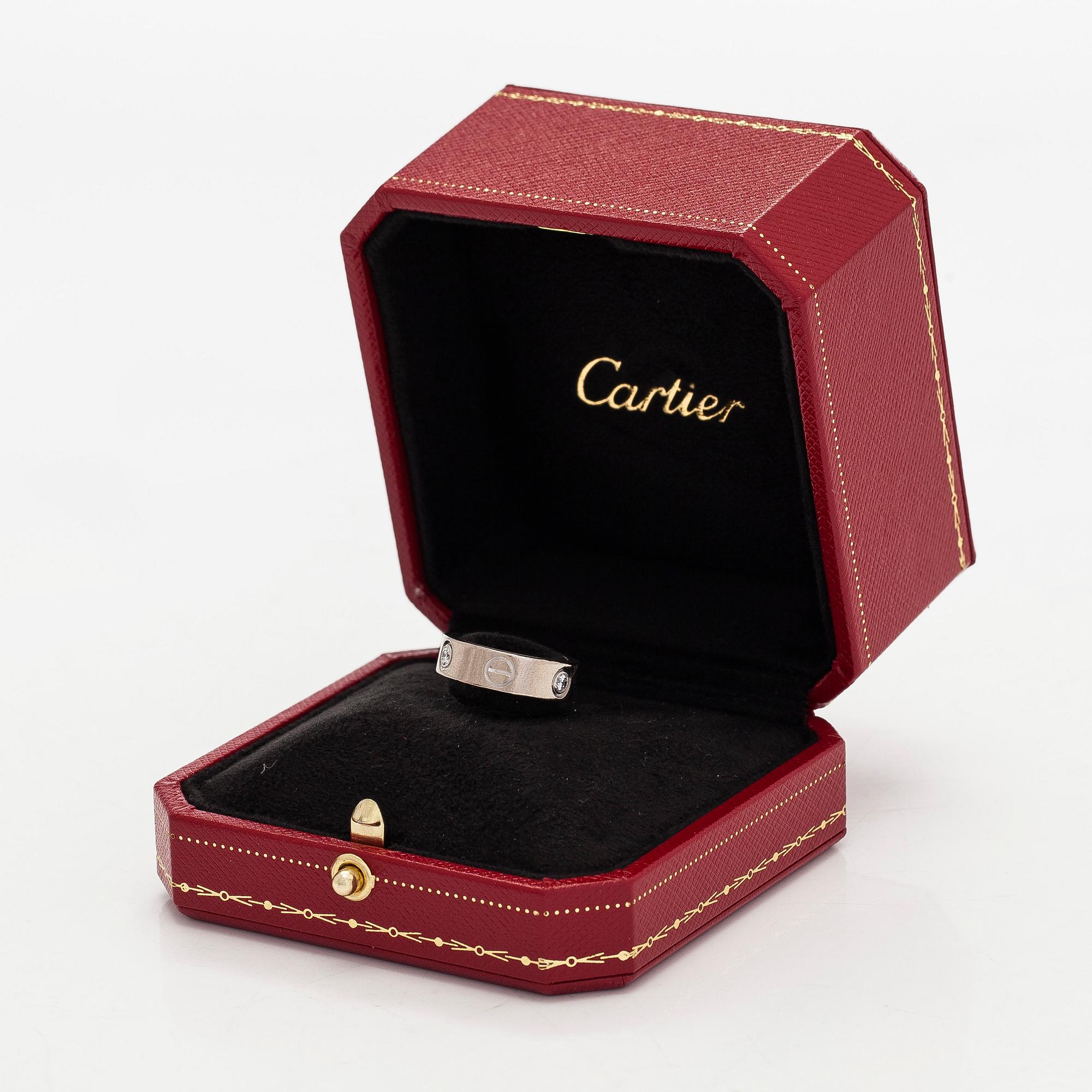Cartier, an 18K white gold 'Love' ring with three brilliant-cut diamonds.
