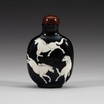 An enamelled porcelain snuff bottle with stopper, Qing dynasty (1644-1912).