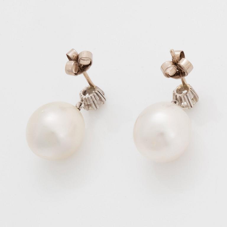 A pair of 18K white gold earrings set with round brilliant-cut diamonds and cultured pearls.