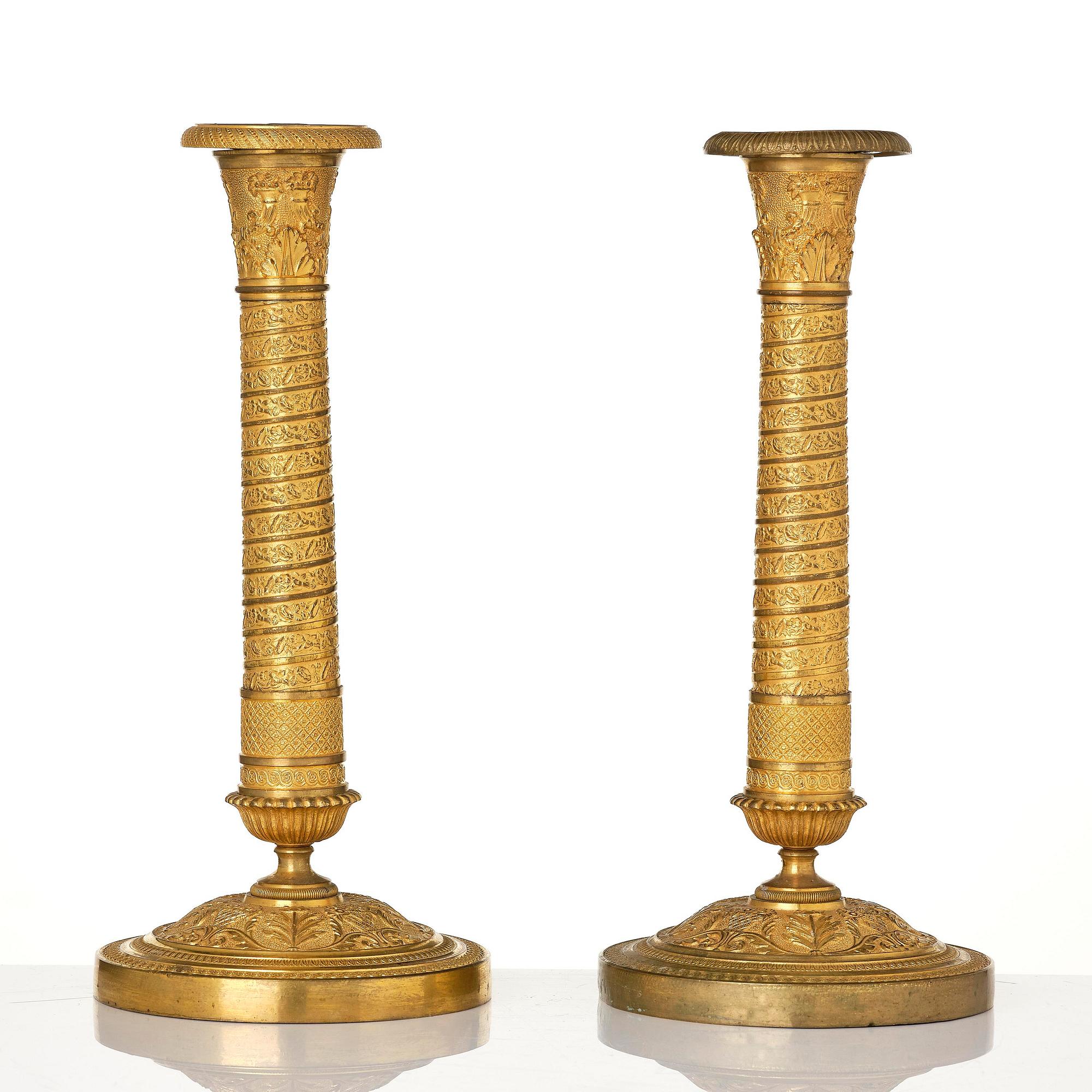 A pair of French Empire ormolu candlesticks, early 19th century.