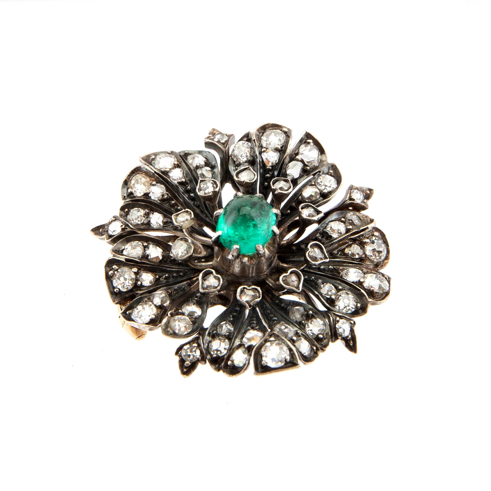 A 14K gold brooch set with a cabochon-cut emerald and old-cut as well as rose-cut diamonds.