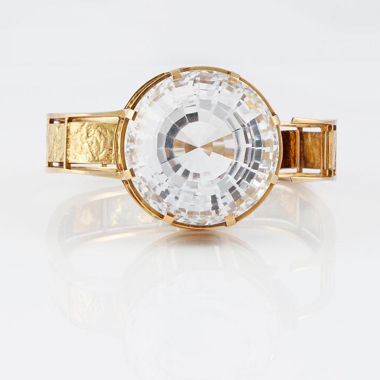 ARMRING, 18K guld med fasettslipad bergkristall, Bengt Rehnvall, Stockholm, 1965. Vikt 62,9 gram.