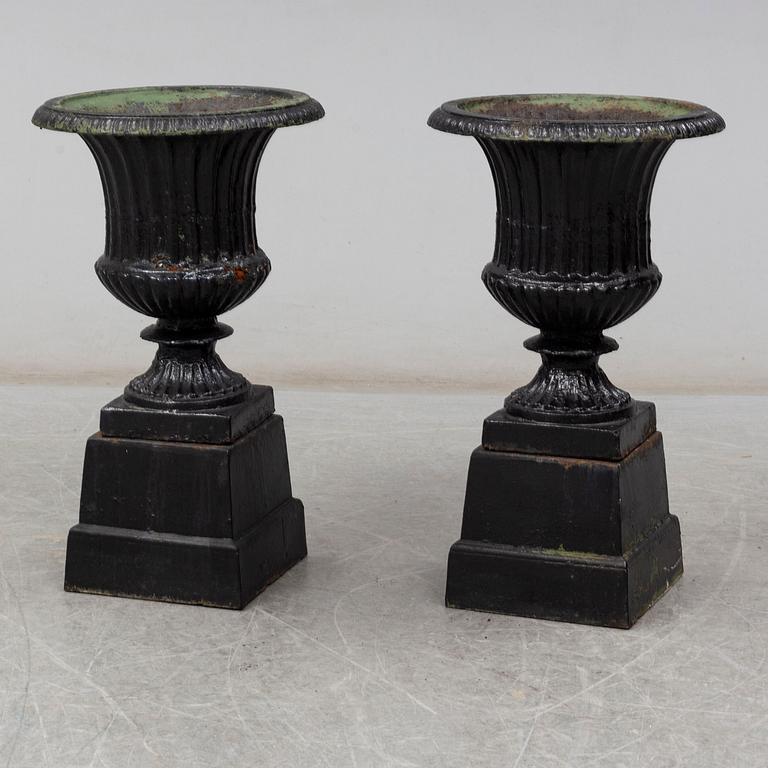 A pair of 20th century cast iron urns.