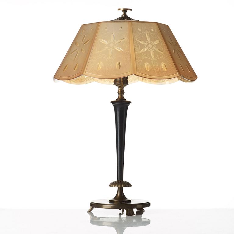 A 1920's patinated metal, lacquered wood, etched och cut glass table lamp, unknown designer, 1920's.