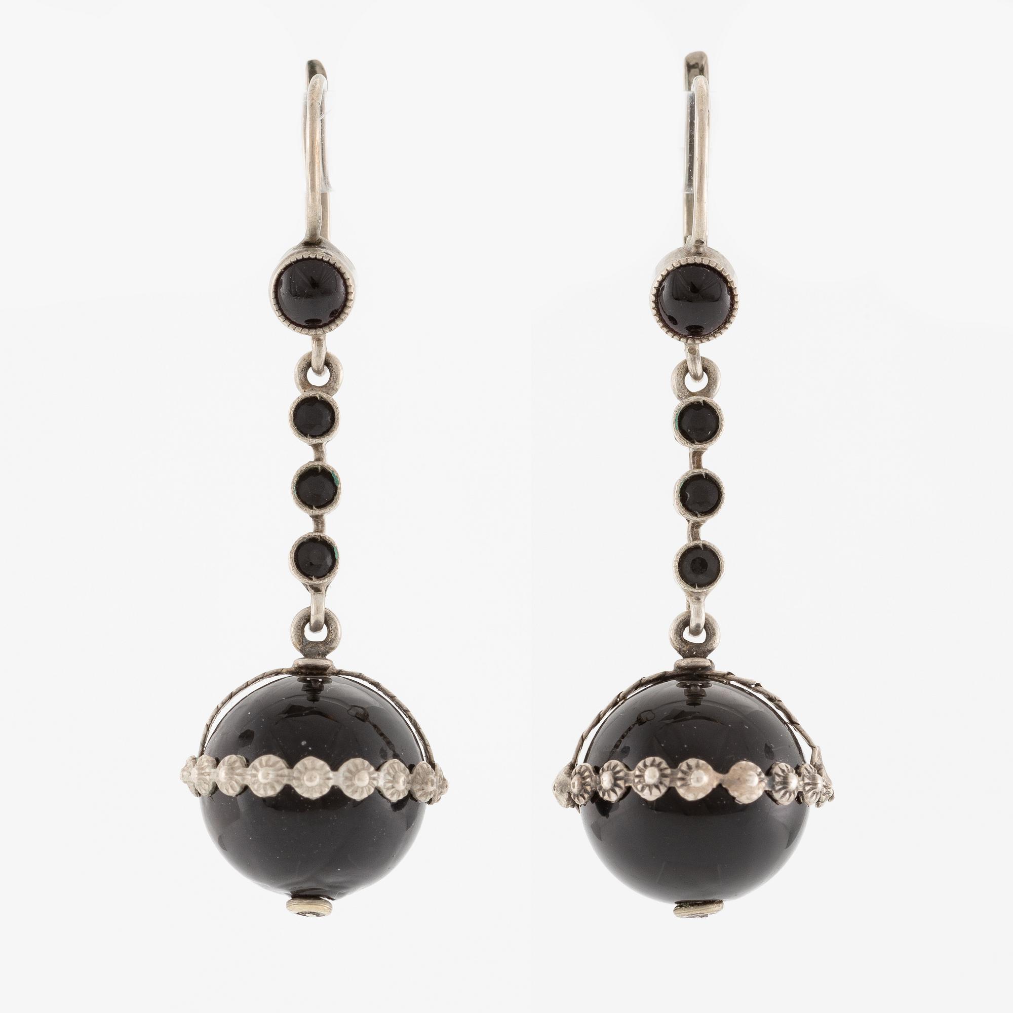 Örhängen silver med svarta stenar.