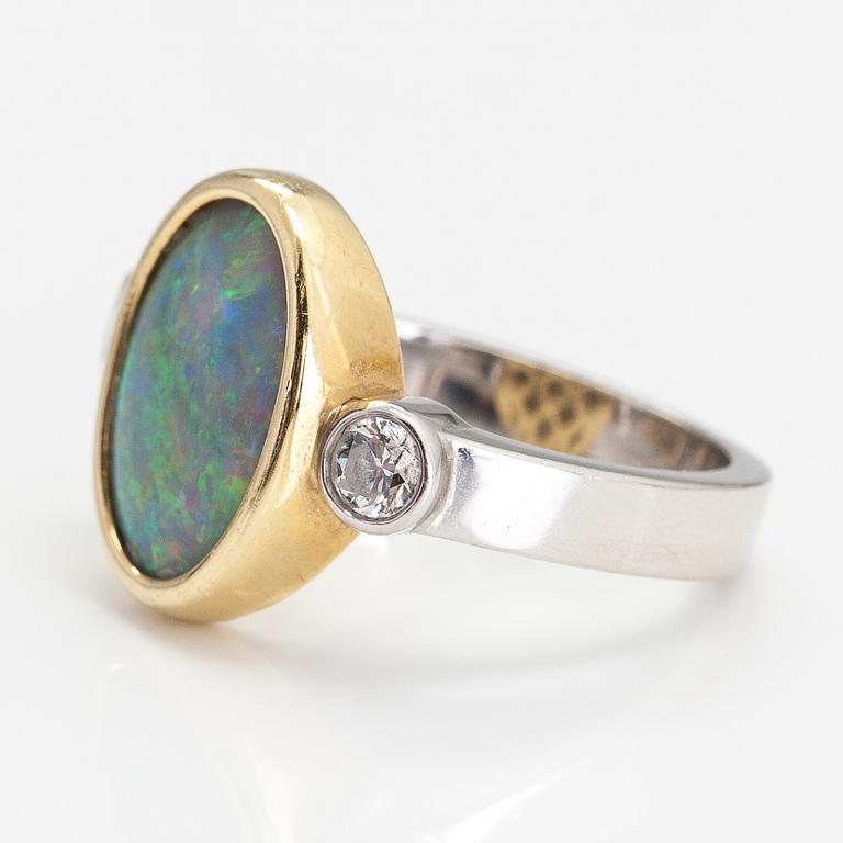 A platinum and 18K gold ring with an opal and diamonds ca. 0.20 ct in total.